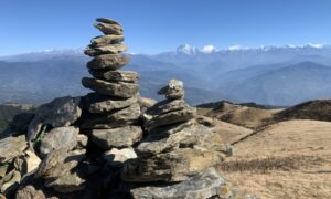 Stacked stones with snowy mountain ranges in the background.