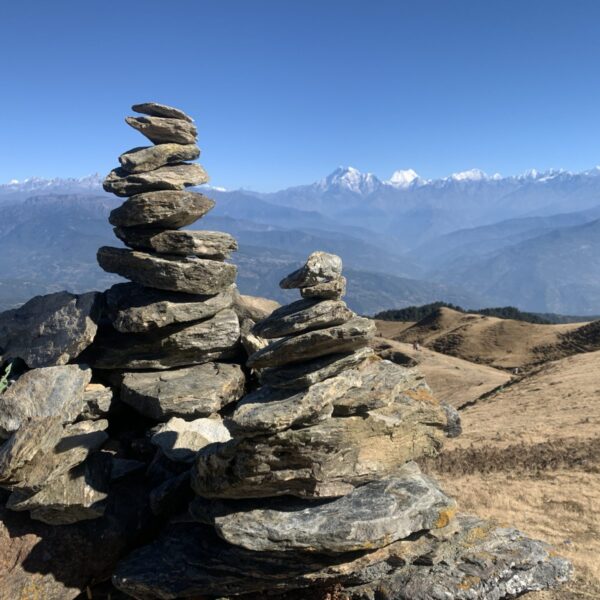 Stacked stones with snowy mountain ranges in the background.